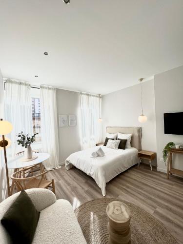 - une chambre blanche avec un lit et un canapé dans l'établissement Le Flocon, à Saint-Étienne