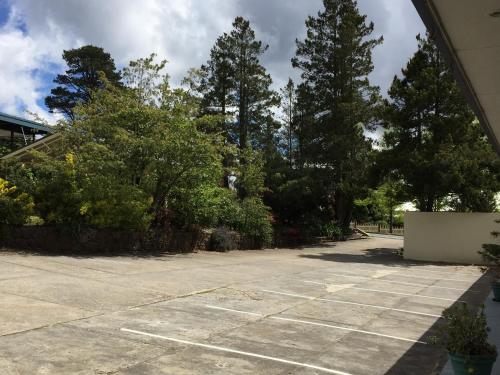 an empty parking lot with trees in the background at High Mountains Motor Inn in Blackheath