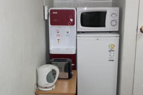 mała kuchnia z kuchenką mikrofalową i lodówką w obiekcie Dongdaemun Guesthouse w Seulu