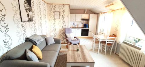 ein Wohnzimmer mit einem Sofa und einem Tisch in der Unterkunft Gästehaus Zur alten Post Wohnung Ost in Dornum