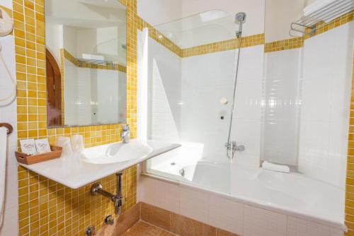 a bathroom with a tub and a sink and a shower at Hotel Castillo de Gauzón in Salinas