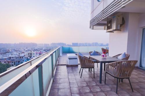 a balcony with a table and chairs and a view at Regenta Suites Gurugram, Sector 49 Sohna Road in Gurgaon