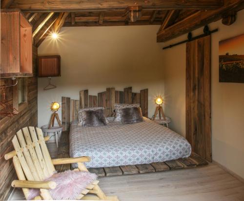 - une chambre avec un lit et un fauteuil à bascule dans l'établissement Gîte de l'Hôtel Dieu, en Bourgogne, avec SPA, à La Bussière-sur-Ouche