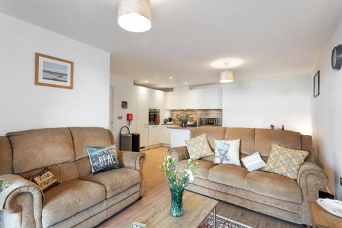 a living room with two brown couches and a kitchen at Host & Stay - Farrier William in Margate