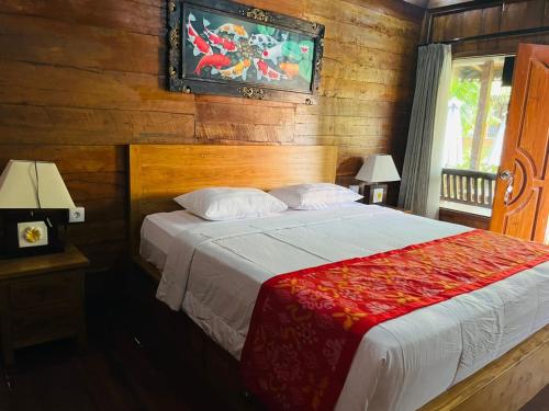 a bedroom with a bed in a room with wooden walls at Bemo Villas & Pool in Karangasem