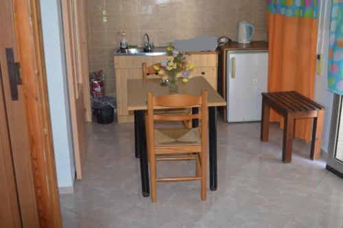 a kitchen with a table and chairs and a refrigerator at HERMOUPOLI ROOMS in Ermoupoli