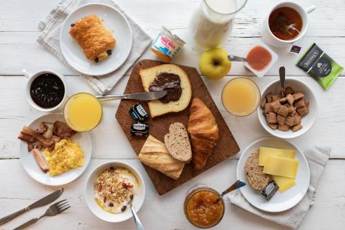 a table with plates of breakfast foods and drinks at B&B HOTEL Ouistreham in Ouistreham