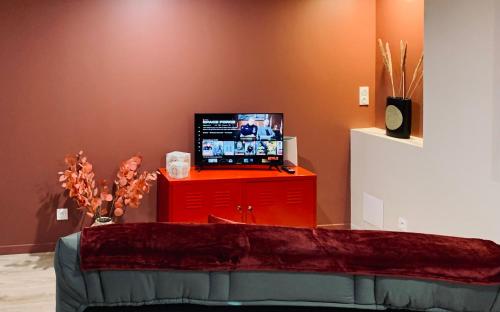 a room with a red dresser with a television on it at Gignac - Superbe cocon indépendant avec balnéo et jardin in Gignac