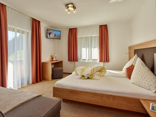 a bedroom with a large bed with red curtains at Fremdenpension Alpenruhe in Sölden