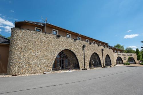 a large stone building with arches on a street at Vinné sklepy Skalák in Skalka