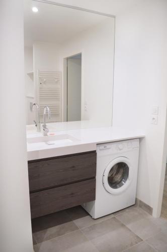 une salle de bain avec un lavabo et une machine à laver dans l'établissement APPARTEMENT ARRADON / PROCHE MER / TOUT ÉQUIPÉ, à Arradon
