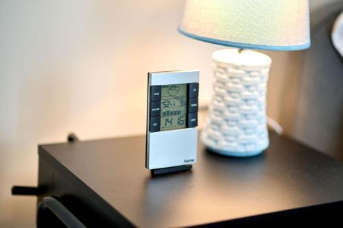 un telecomando seduto su un tavolo accanto a una lampada di Sea Nest Studio in NorD10 By Alezzi a Mamaia