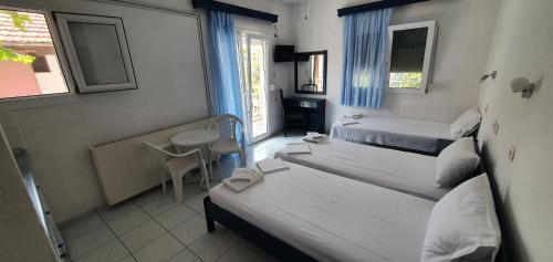 ein kleines Zimmer mit 2 Betten und einem Fenster in der Unterkunft Toula's Apartments in Platamonas