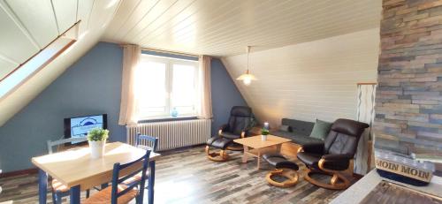 ein Wohnzimmer mit Stühlen, einem Tisch und einem Sofa in der Unterkunft Gästehaus Zur alten Post - Landhaus DG in Dornum