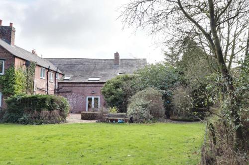 a house with a yard with a bench in front of it at Bretton House Farm Retreat in Chester