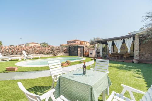 a table with a bottle of wine sitting on top of a yard at Villa Marisa in Budoni