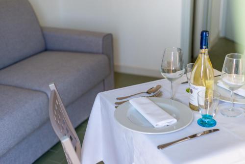 a table with a bottle of wine and wine glasses at Residence Marina di Cecina in Marina di Cecina