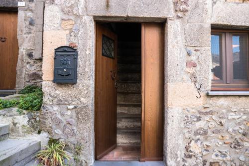 a stone building with a door and stairs next to a door at Su Cucumiao - Tipica casa con terraza panoramica in Santu Lussurgiu