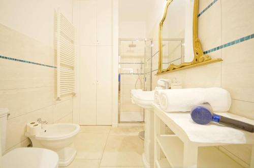 a white bathroom with two sinks and a toilet at DolceVita Apartments N. 499 Biennale in Venice