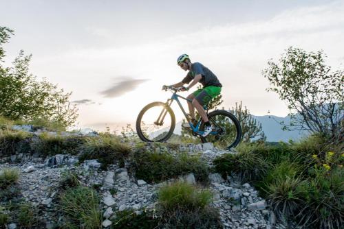 a man riding a bike on a rocky trail at Hotel Residence La Pertica in Tremosine Sul Garda