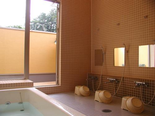 a bathroom with a bath tub and a window at PICA Fujiyoshida in Fujiyoshida