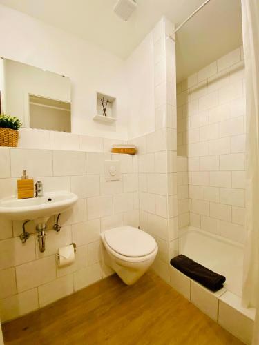 a bathroom with a toilet and a sink and a tub at Pension Garni No.11 in Dresden