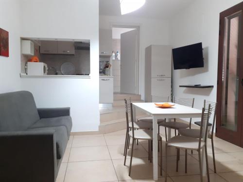 salon ze stołem, krzesłami i kanapą w obiekcie B&B Soleluna w mieście Veglie