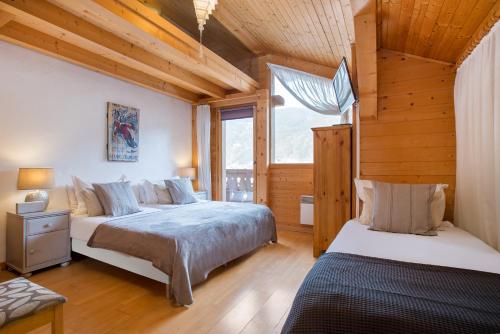 une chambre avec deux lits et une fenêtre dans l'établissement Chalet Muguet Gauche with Hot Tub Sleeps 10 Central Morzine, à Morzine