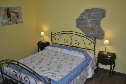 1 dormitorio con 1 cama con 2 lámparas en las mesas en Apartment Pod Kostanji en Osp