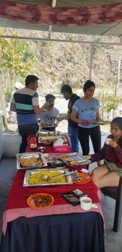 a group of people standing around a table with food at The Raajas - Camp & Resorts in Rishīkesh
