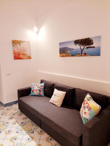 a brown couch in a living room with two pillows at La Bomboniera in Maiori