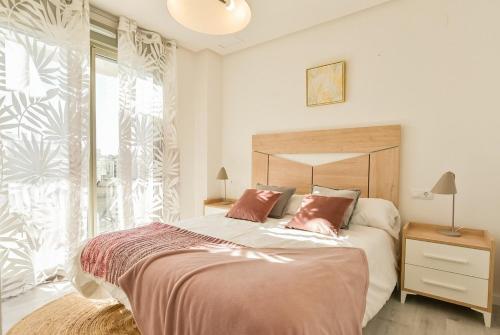 a bedroom with a bed and a large window at 215 Penthouse SPA GOLF - Alicante Holiday in Villamartin