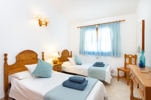 a bedroom with two beds with blue pillows on them at CASA GOLF beautiful views with private pool in San Miguel de Abona