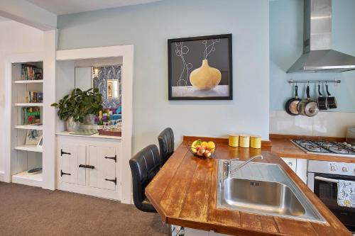a kitchen with a wooden table and a sink at The Granville - Delightful 2-bed Victorian Apartment in Harrogate