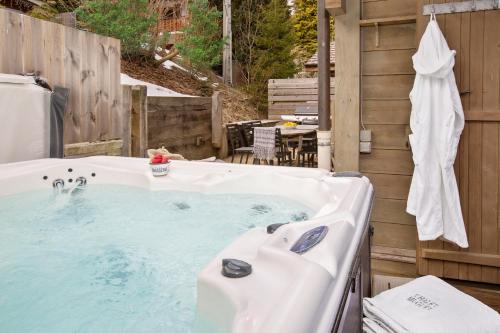 une baignoire installée à côté d'un mur en bois dans l'établissement Chalet Muguet Gauche with Hot Tub Sleeps 10 Central Morzine, à Morzine