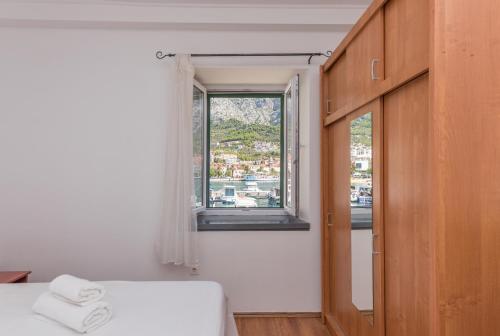Pokój z łóżkiem i oknem z ręcznikami w obiekcie Apartment Alen w Makarskiej