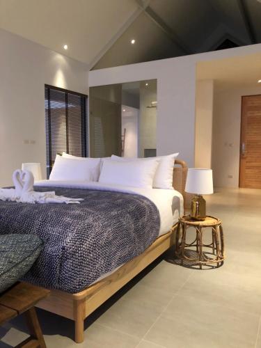 a bedroom with a large bed and a table with a lamp at Little Moon Villa in Ko Mak