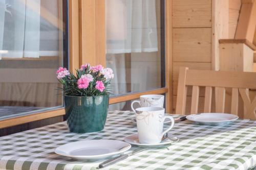 a table with plates and a vase with flowers on it at Ferienwohnung Susi im Neubau in Farchant