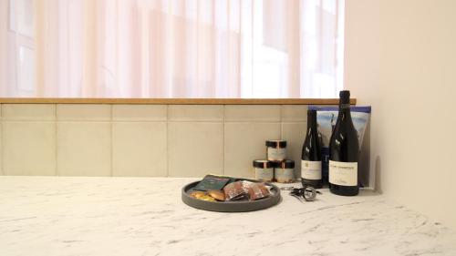 a plate of food and bottles of wine on a counter at MiHotel Sala in Lyon