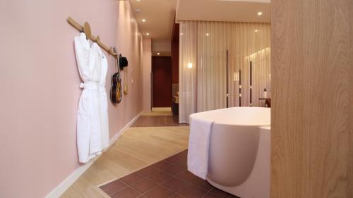 La salle de bains est pourvue d'une baignoire blanche et d'un lavabo. dans l'établissement MiHotel Sala, à Lyon