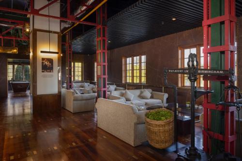 a lobby with couches and a cross in the middle at Heritance Tea Factory in Nuwara Eliya