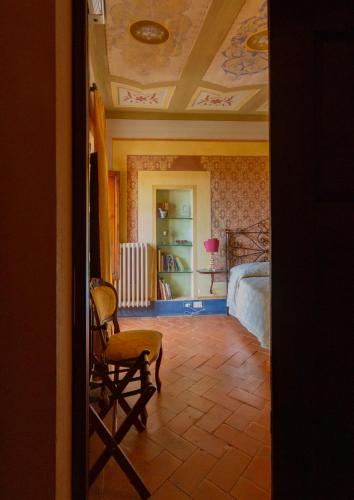 a room with a bedroom with a bed and a chair at Antica Dimora Leones in Palaia