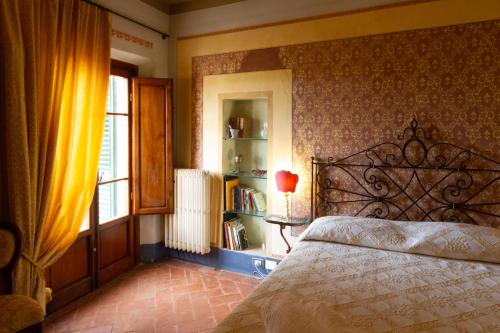 een slaapkamer met een bed en een boekenplank bij Antica Dimora Leones in Palaia