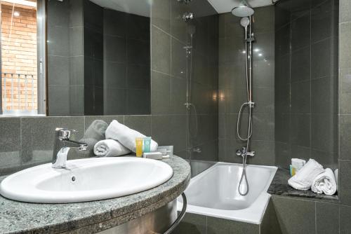 a bathroom with a sink and a bath tub at Hotel Sansi Park in Lleida