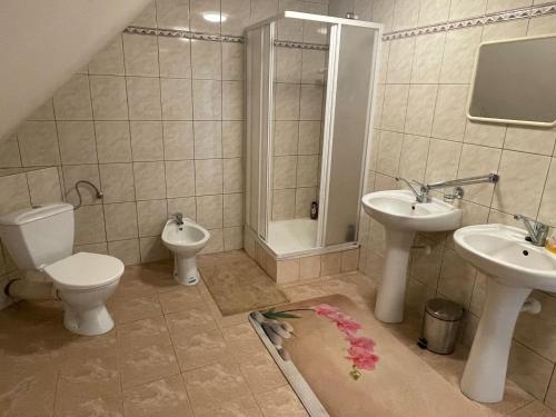 a bathroom with two sinks and a toilet and a shower at Apartmán Beruška in Křelovice