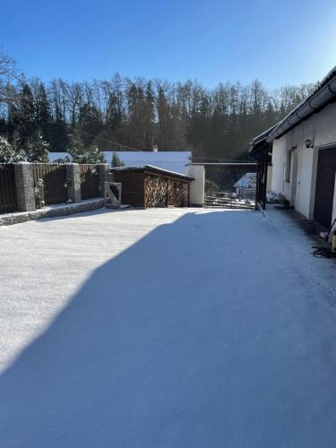a driveway covered in snow next to a house at Apartmán Beruška in Křelovice