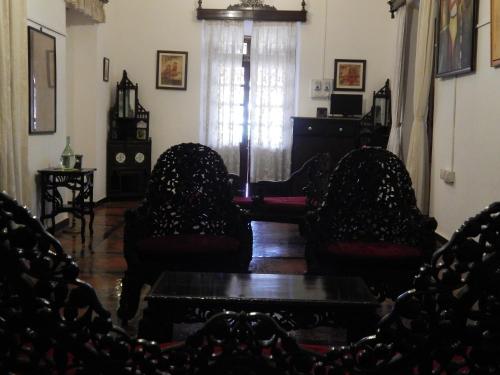 a living room with two chairs and a table at WelcomHeritage Panjim Inn in Panaji