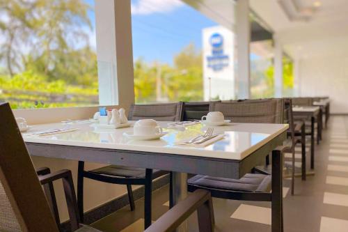 a dining room with a table with chairs and a tableasteryasteryasteryasteryastery at Best Western Phuket Ocean Resort in Karon Beach