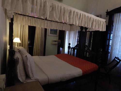 a bedroom with a bed with a canopy at WelcomHeritage Panjim Inn in Panaji