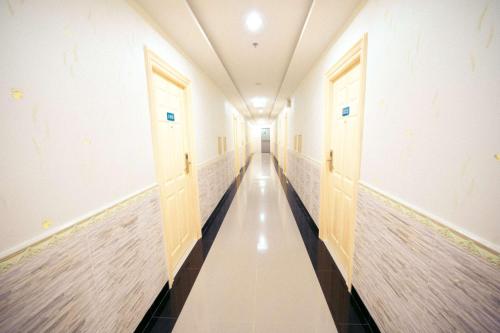 a hallway with two doors and a long corridor at Best Western Royal Buriram in Buriram